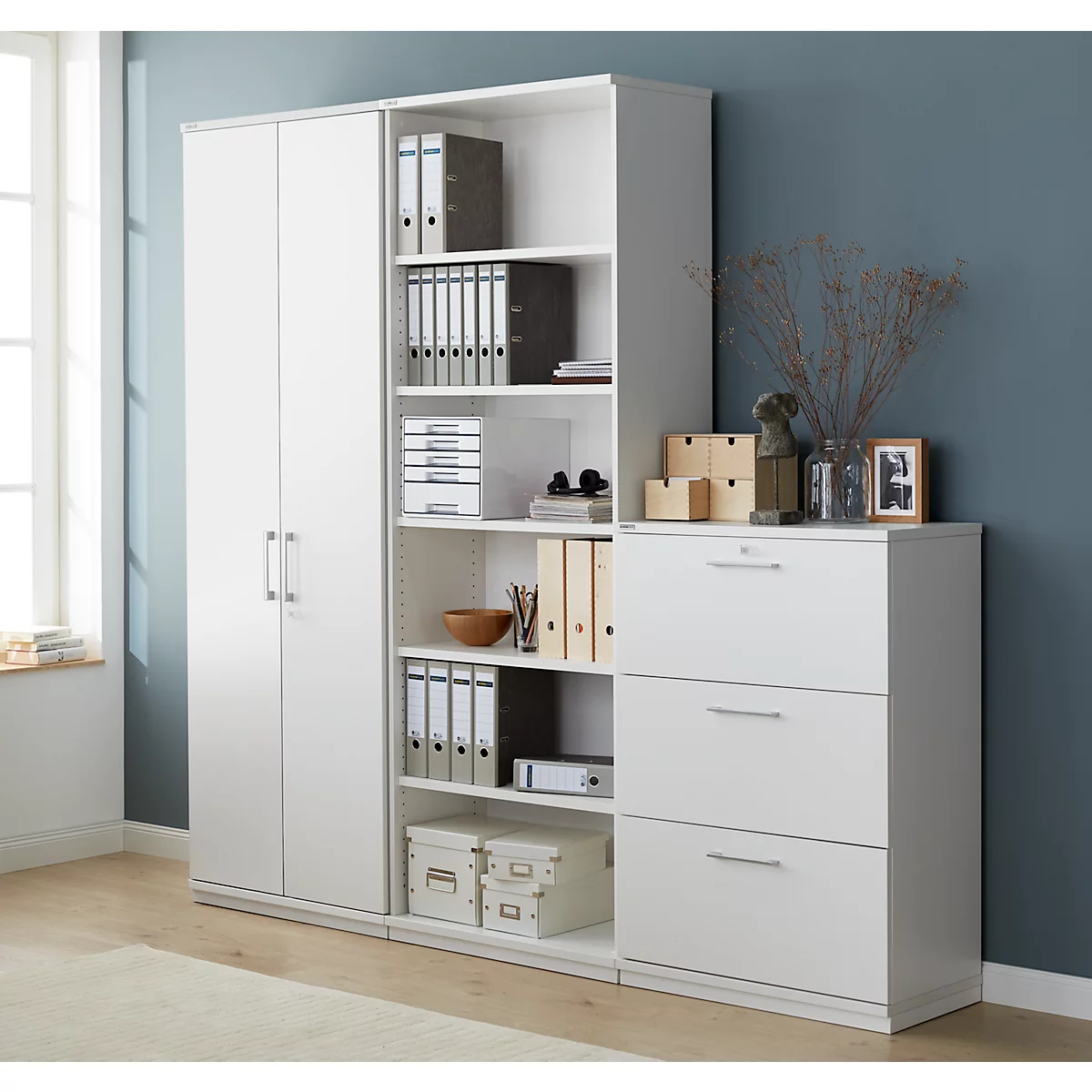 A white office combination of cabinet, shelves, and drawers. File folders and office supplies are stored.