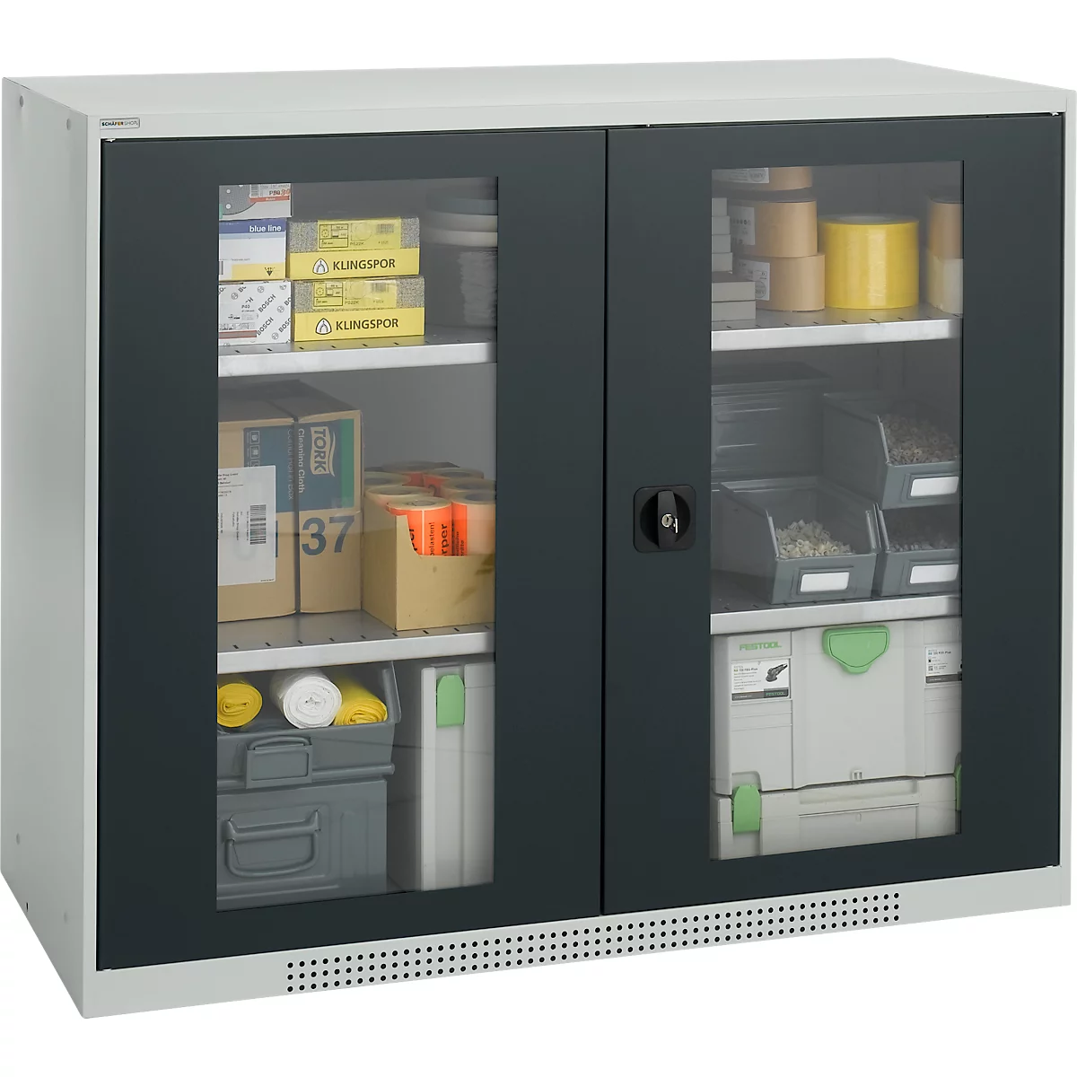 Tool cabinet with glass insert. Tools, screws and packaging are in the compartments. Black frame, white housing.