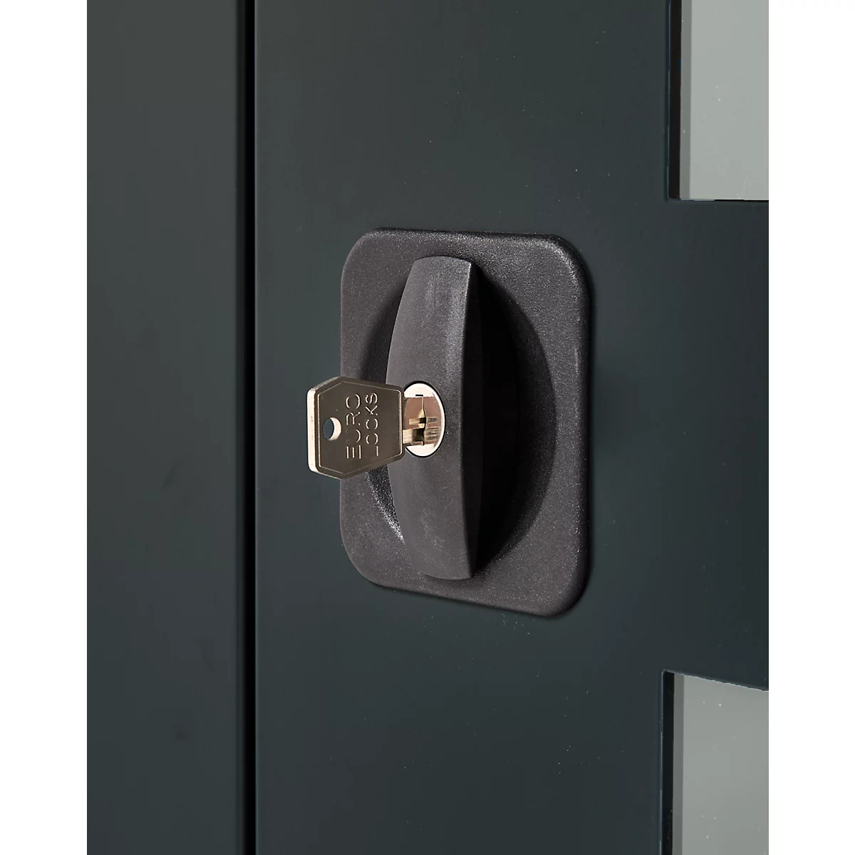 Close-up of a black door handle with a key inserted. The handle is rectangular with rounded corners.
