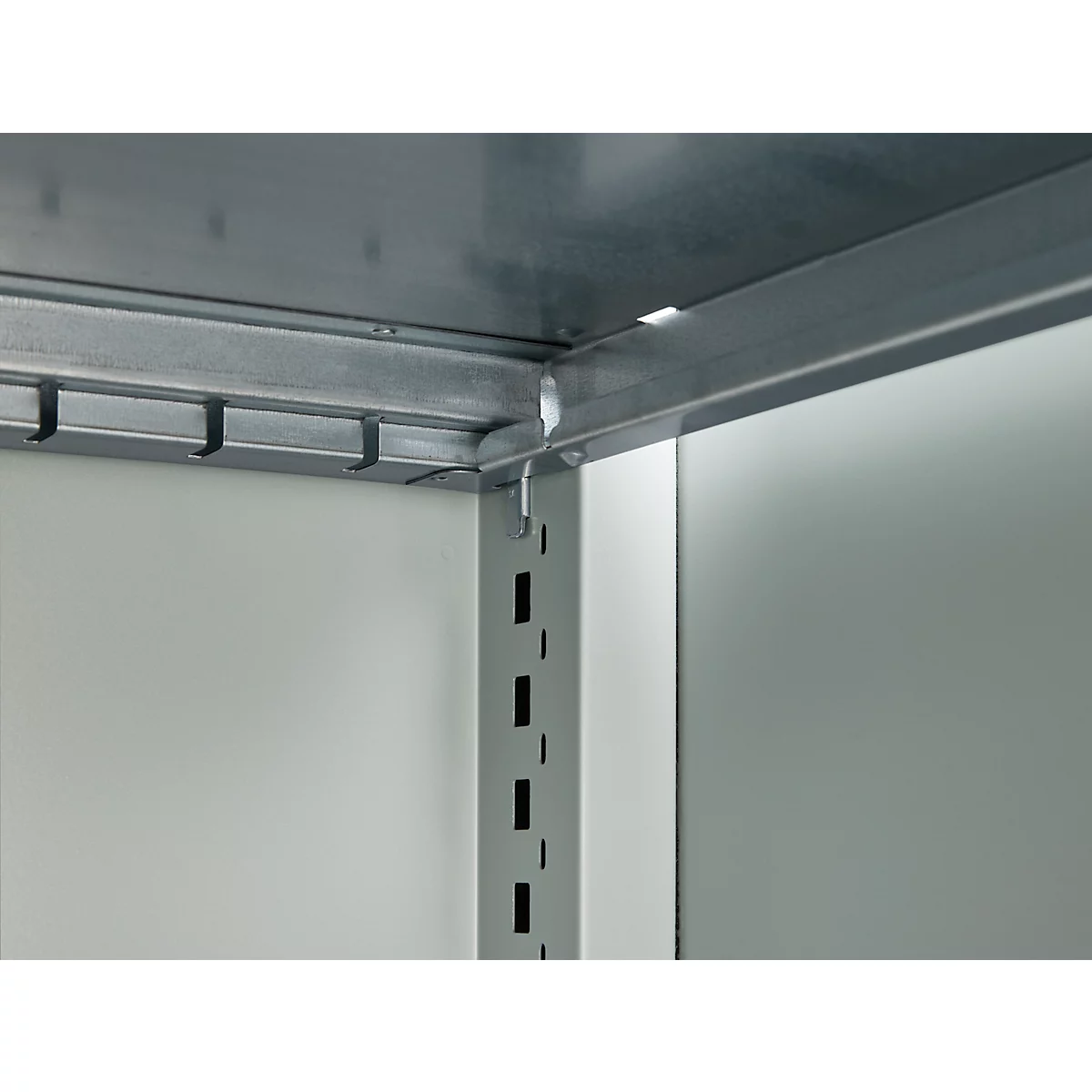 Close-up of shelf frame with hooks. The frame is made of metal, the wall is gray.