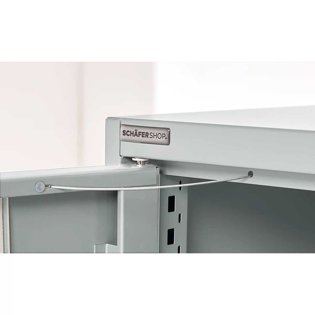 Close-up of a grey cabinet with an open door and a 'SCHÄFERSHOP' sign.
