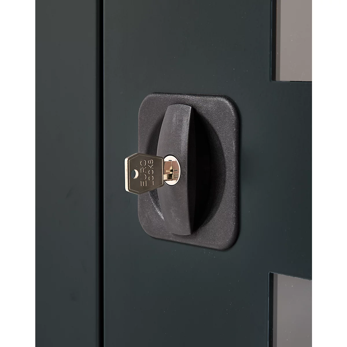 Close-up of a dark cabinet lock with key. The key is inserted into the lock.