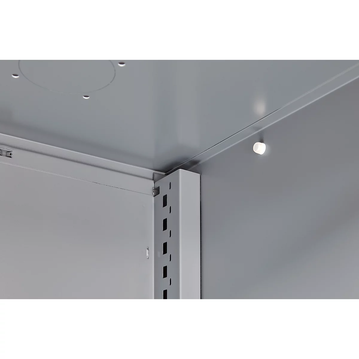 Inside view of a cabinet: angles and brackets. Light source on the ceiling.
