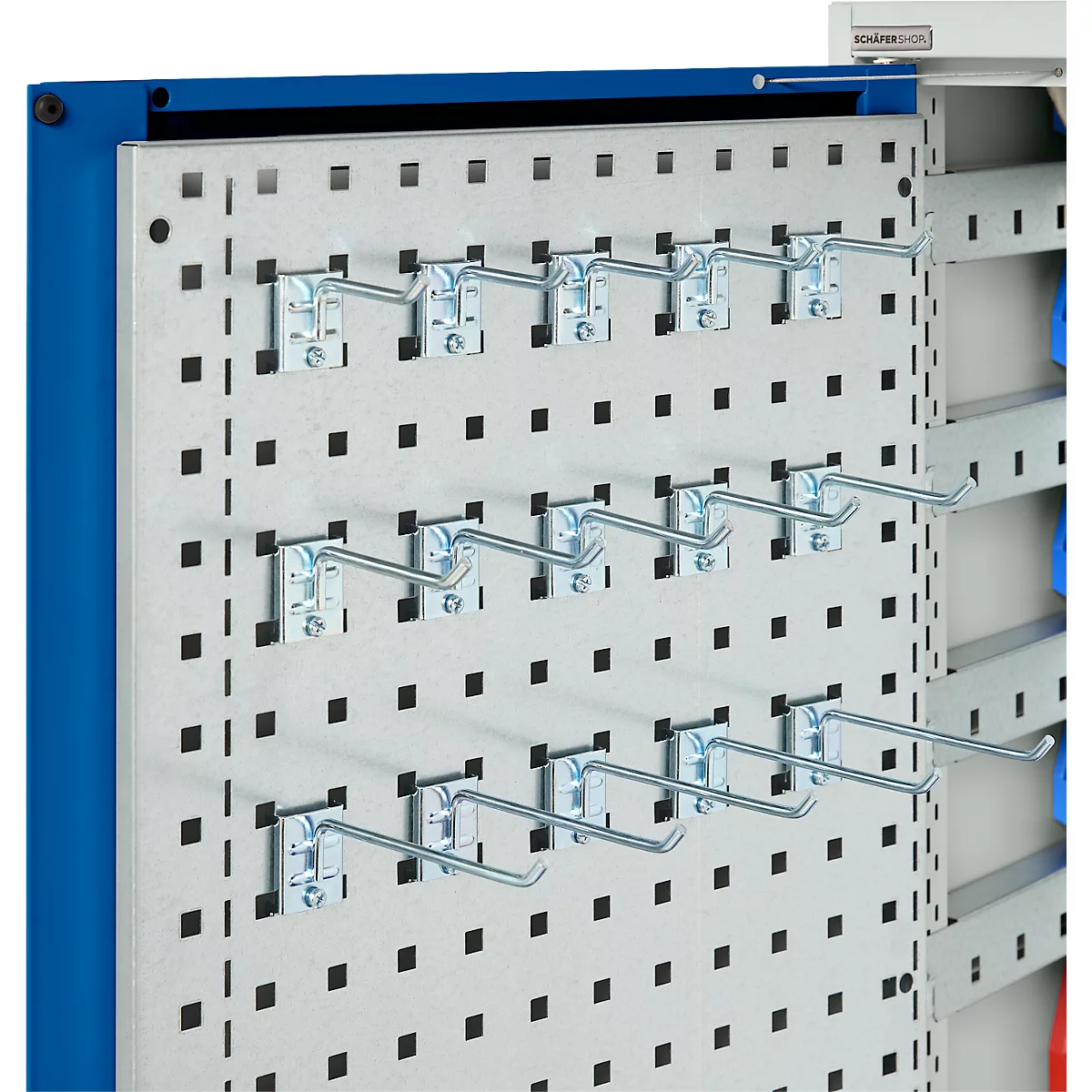 Graue Lochwand mit Haken. Schwarze Quadrate bilden das Muster. Blaue Metallumrandung.