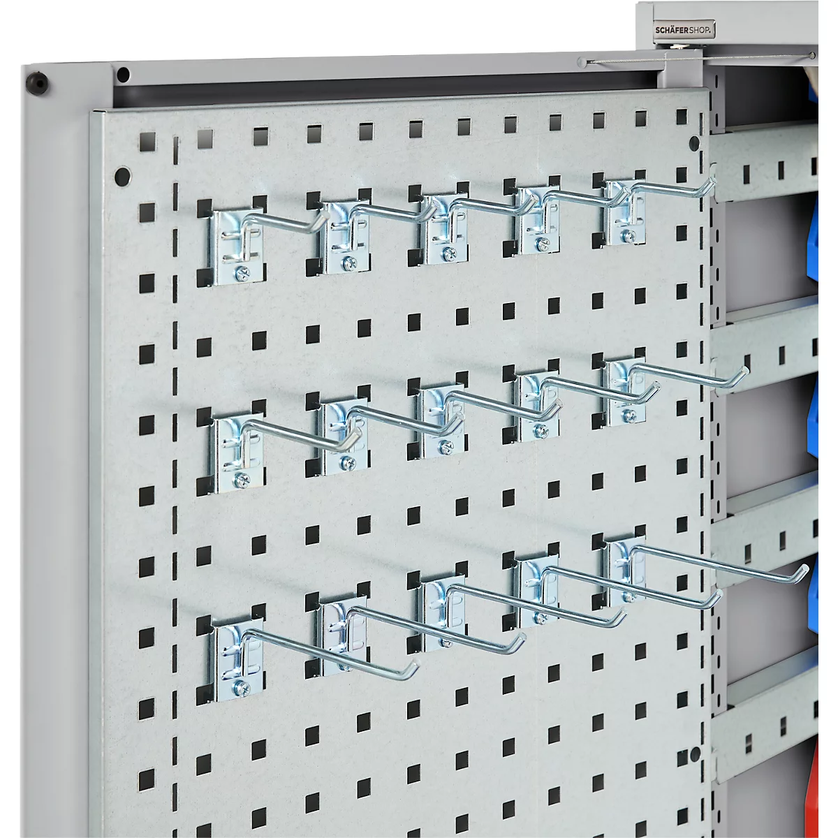 Nahaufnahme einer Lochwand mit Metallhaken. Das Logo "SCHÄFER SHOP" ist sichtbar.