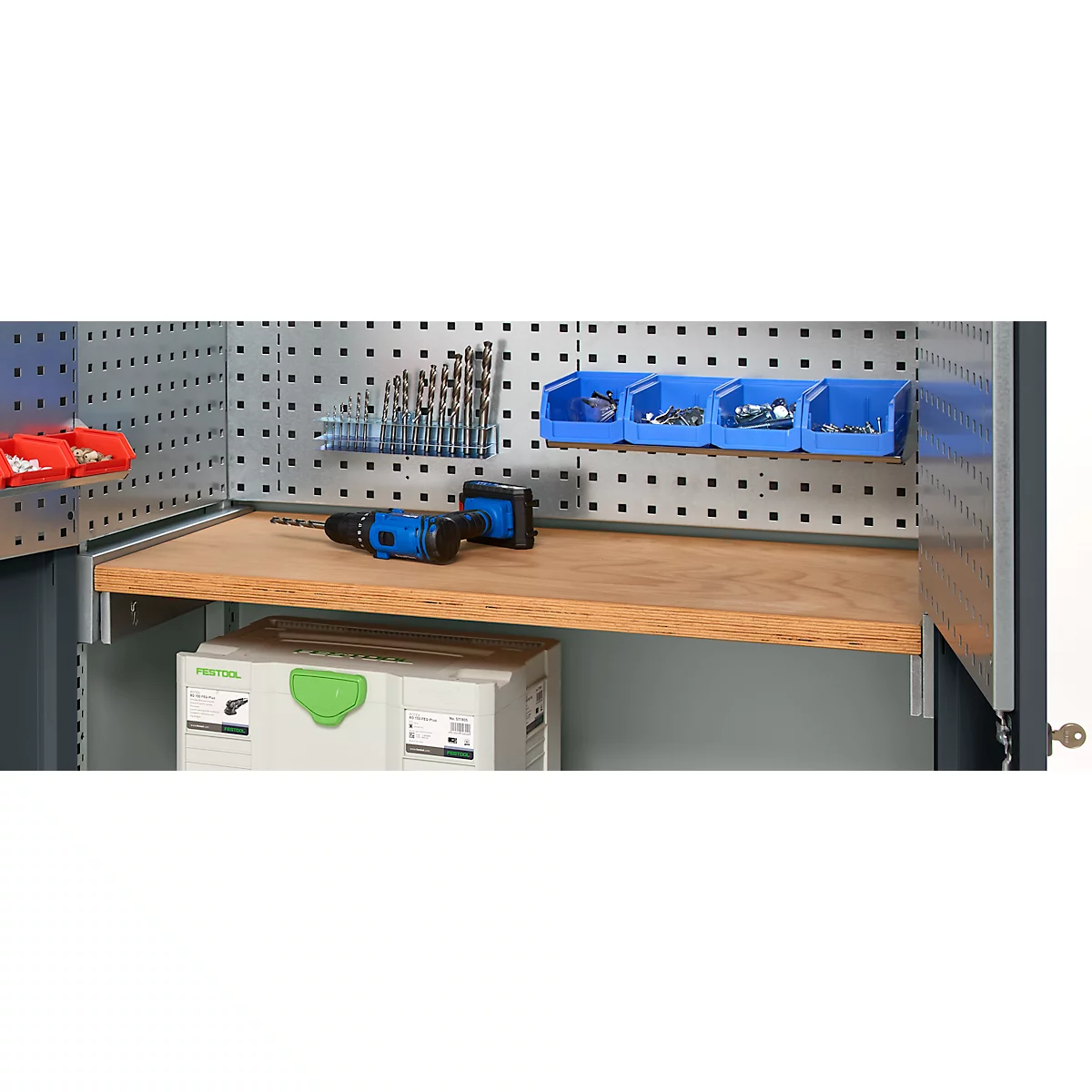 Tool cabinet with drill, drill bits and screws. A blue drill lies on the shelf.