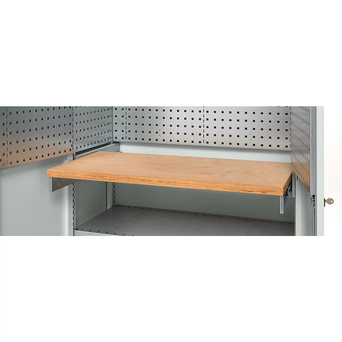 A wooden shelf is mounted on metal brackets inside a cabinet, with a pegboard above it.