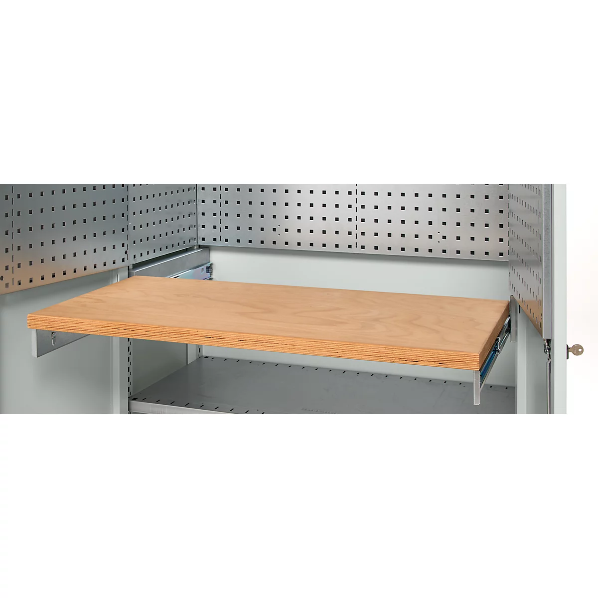 Wooden panel as an extension in a workshop cabinet, with a perforated panel wall behind.