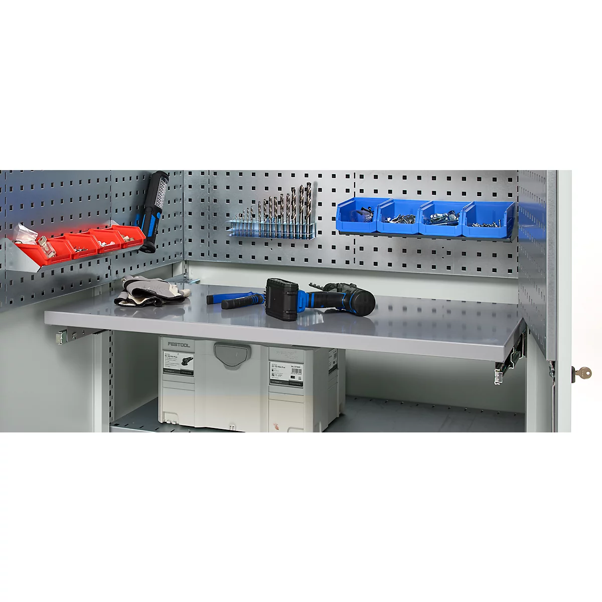 Tool cabinet with tools and accessories. A drill and gloves are on the work surface. A pegboard with tools in the background.