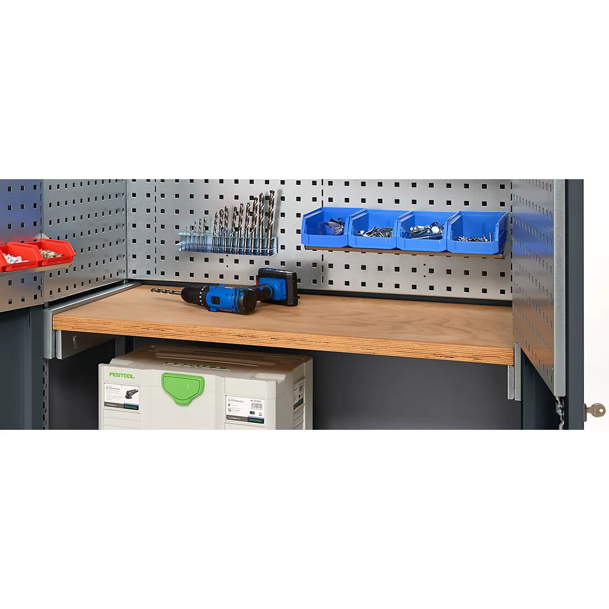 Workbench with tools: drill bits, blue storage bins with screws, wooden shelf, cordless drill.