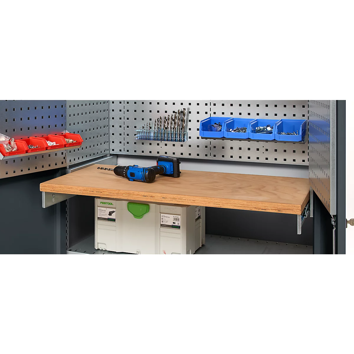 Workbench with accessories, tools, drawers, drill and wooden board.