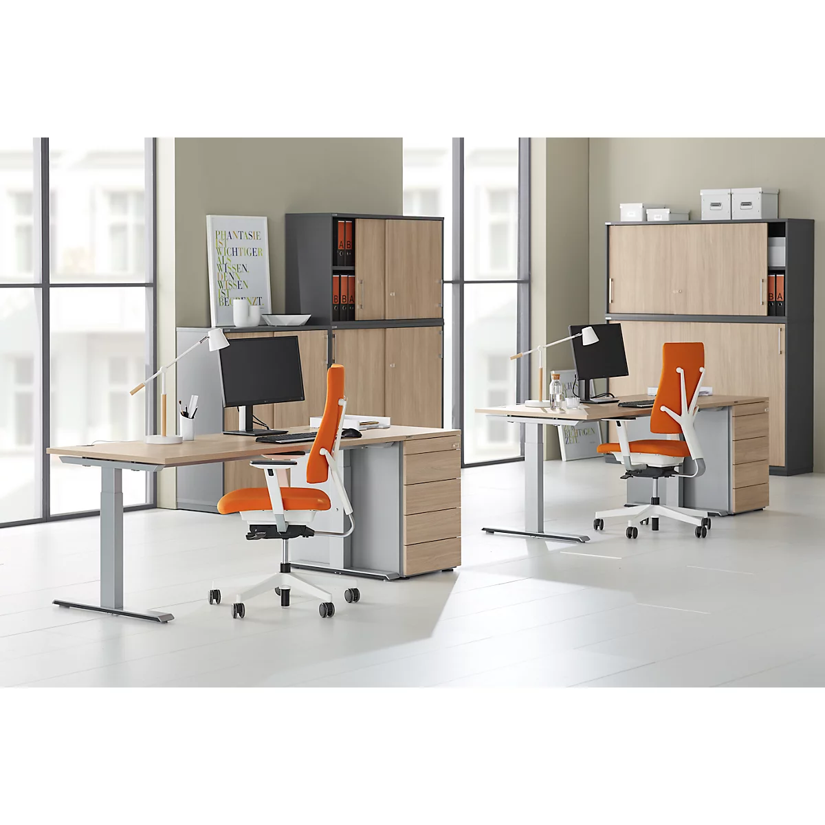 Office with two desks, chairs, cabinets. Orange chairs, wood look, silver frames. Monitors on the tables.