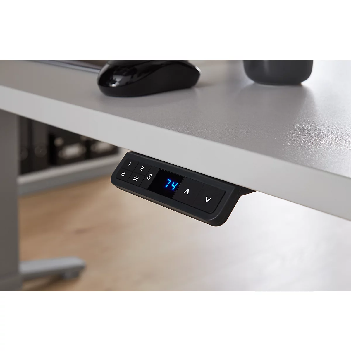 Detailansicht der Bedienelemente eines höhenverstellbaren Schreibtisches. Auf dem Display steht 74.