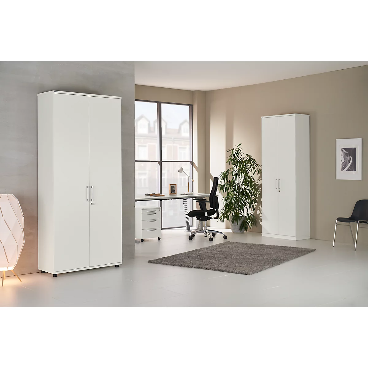 A bright office space featuring white cabinets, a desk, a chair, and a green rug.