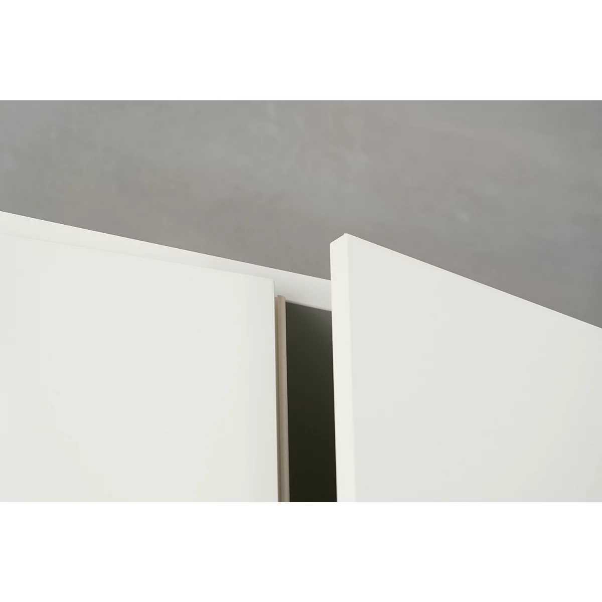 Close-up: White cabinet doors, open, with dark interior against a gray background.