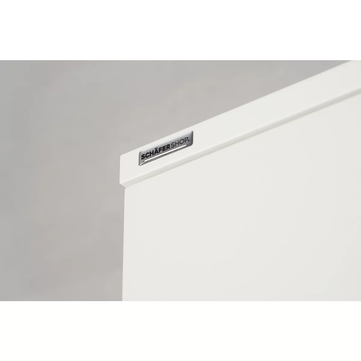 Detail shot of a white piece of furniture with "SCHÄFER SHOP" logo.