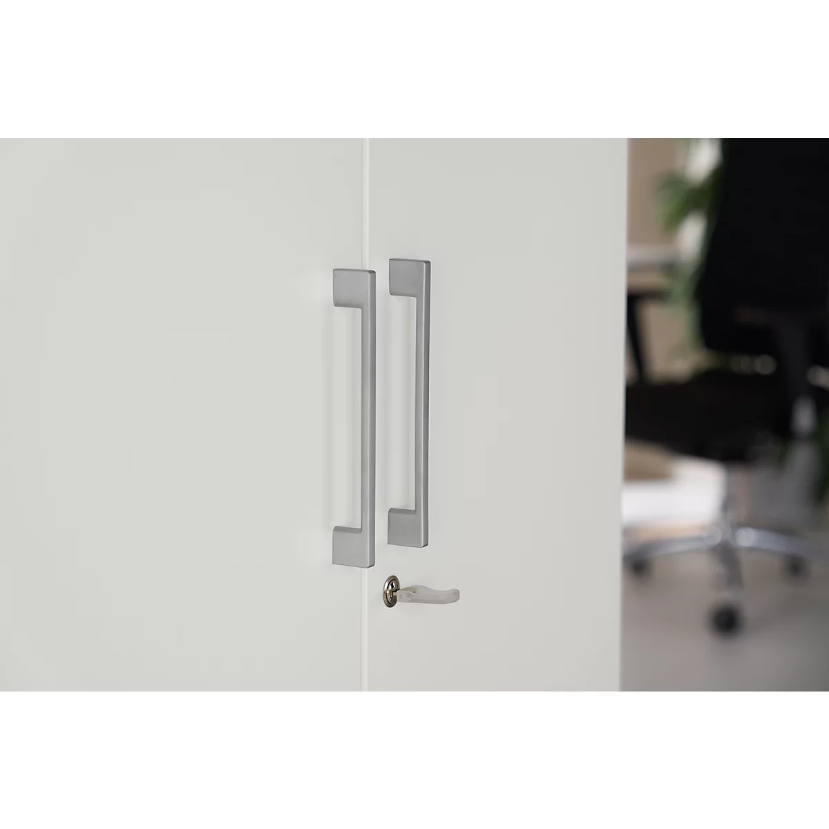 White cabinet door with two long, silver handles and a keyhole.