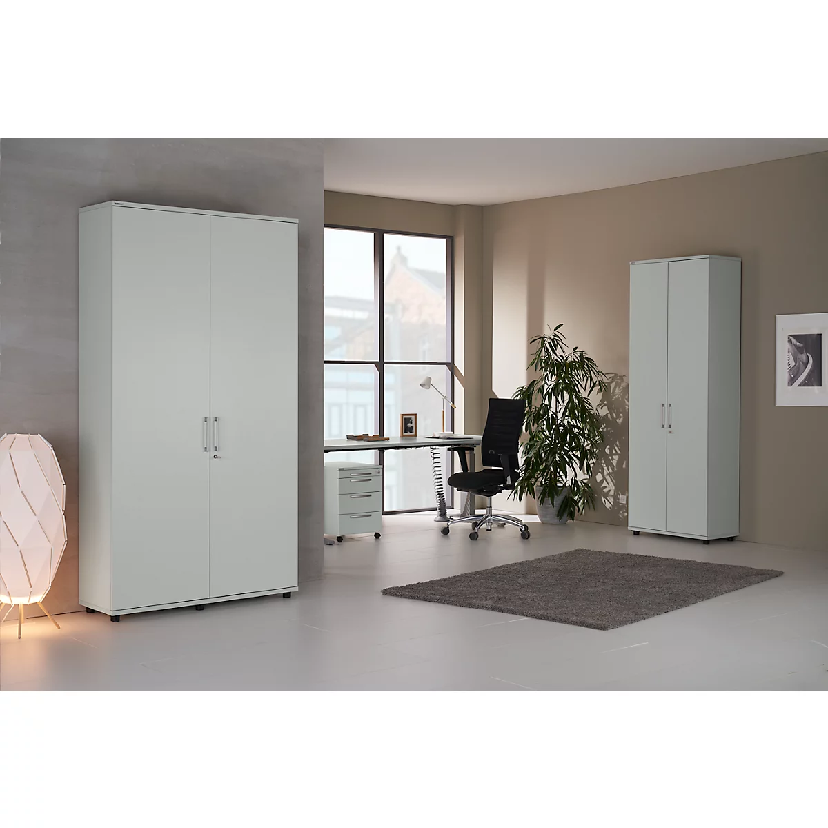 Office space featuring white cabinets, a desk, office chair, and plants. A rug is on the floor.