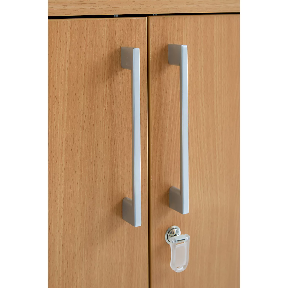 Close-up of a wooden cabinet door with silver handles and a key.