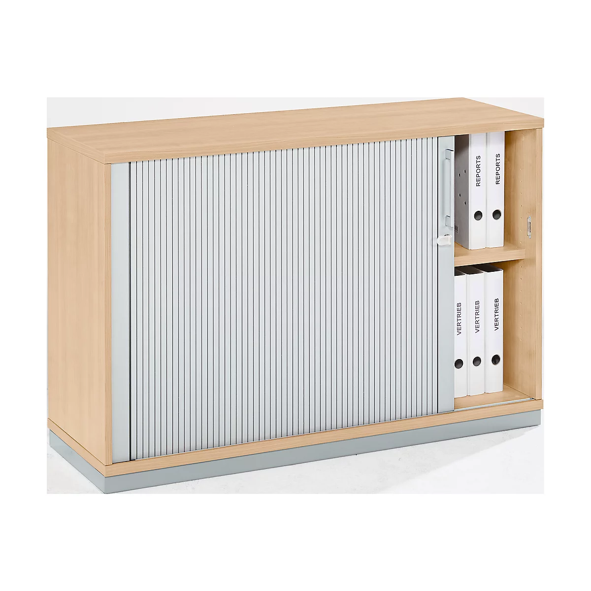 Wooden cabinet with slatted door, half open. Behind it, folders with the labels "Reports" and "Vertrieb".
