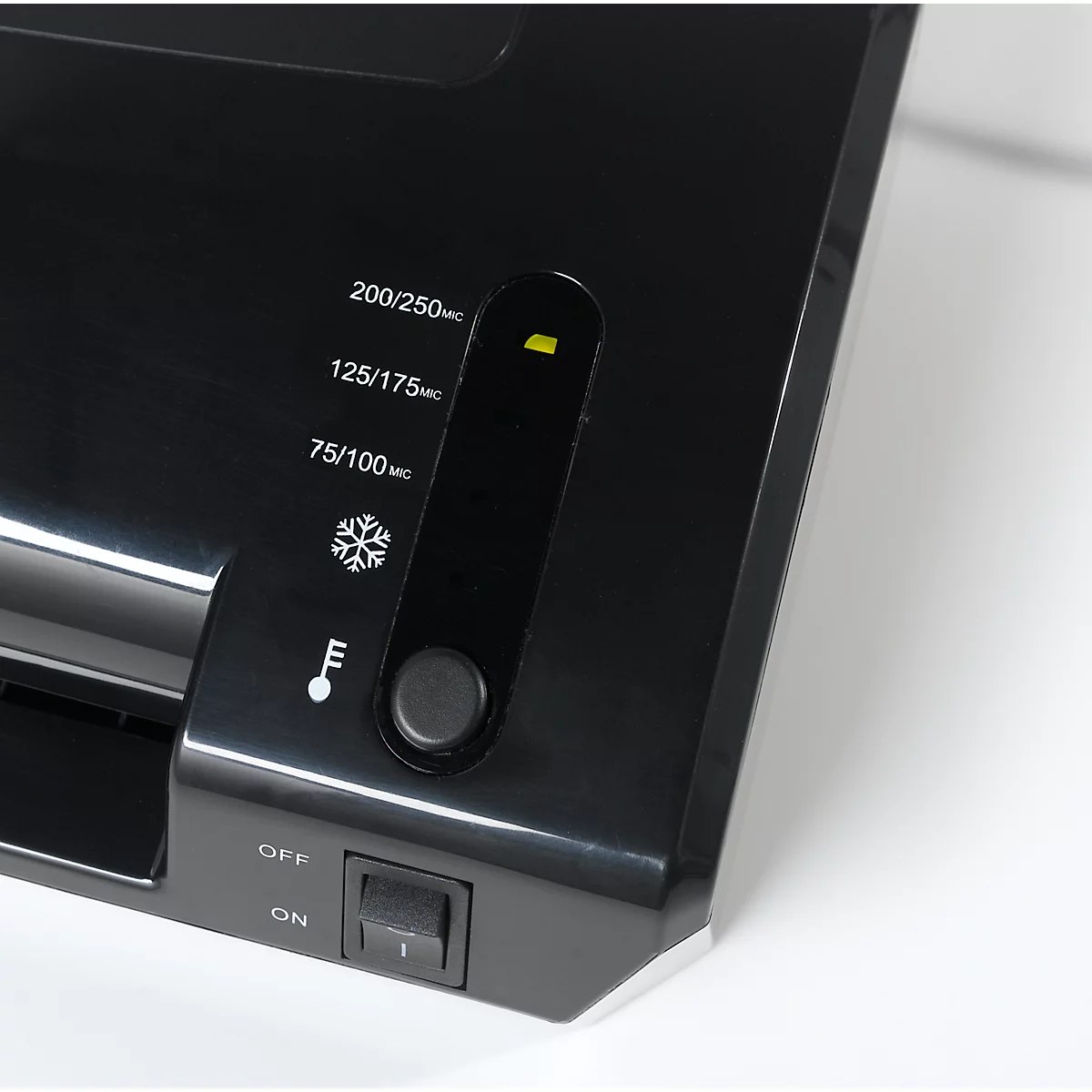 Close-up of a black laminator. Control panel with indicators, temperature gauge and on/off switch. Labels: 200/250, 125/175, 75/100, OFF/ON.