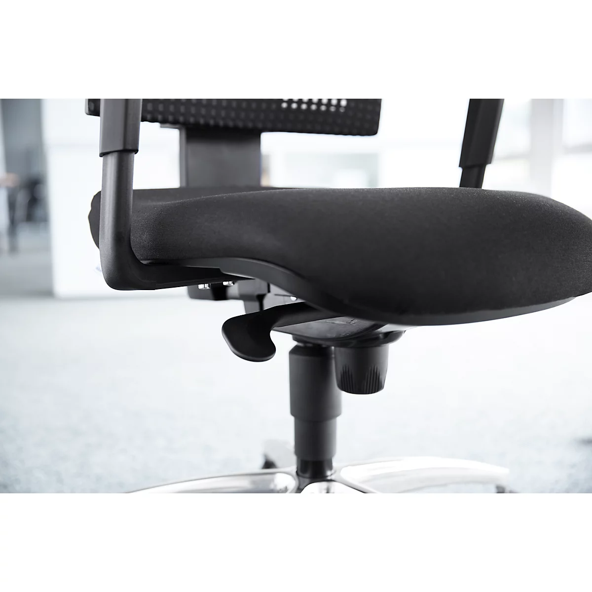 Close-up of a black office chair. The seat is padded, the armrest is made of plastic.