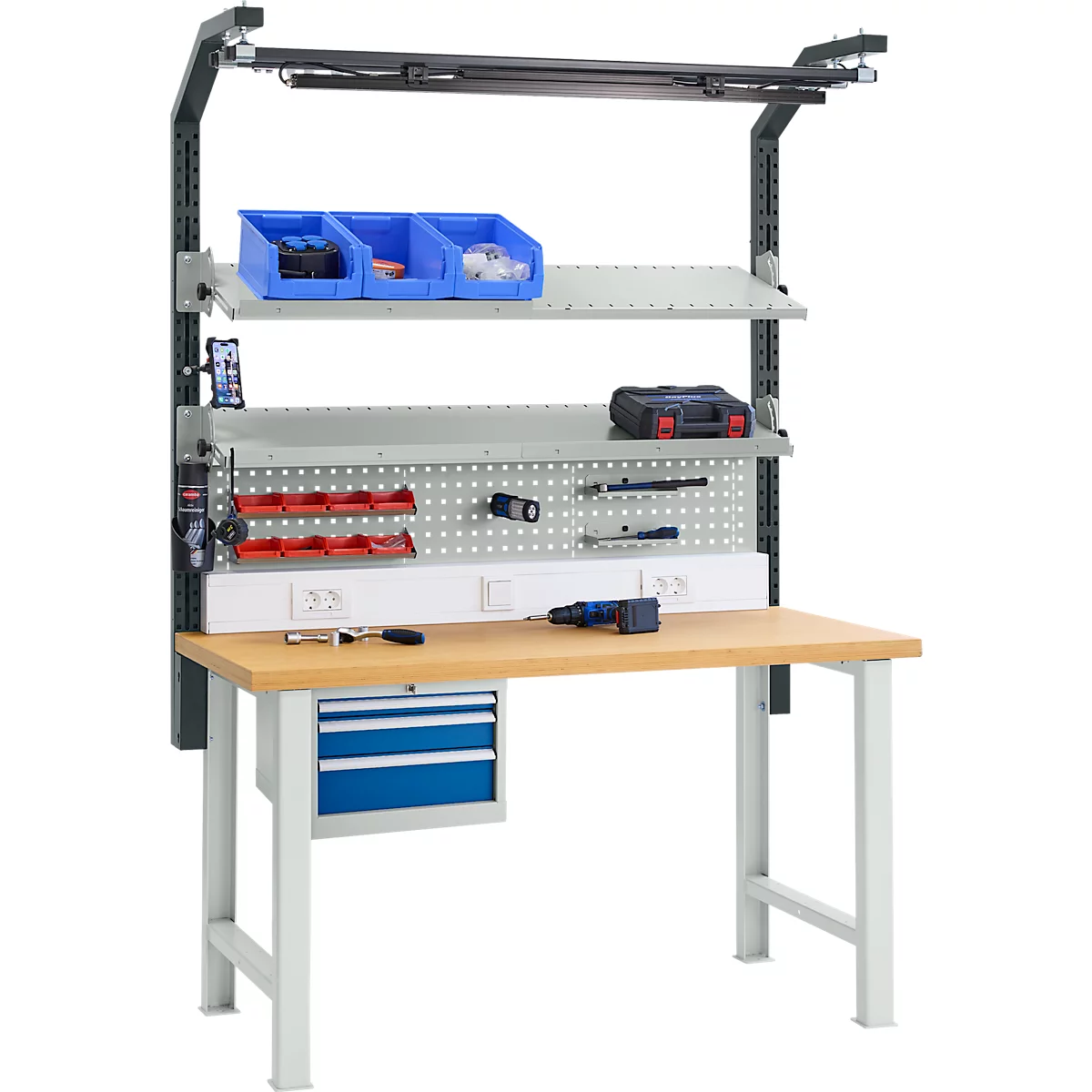 Workbench with tools and accessories, illuminated. Blue drawers and boxes, gray pegboard.