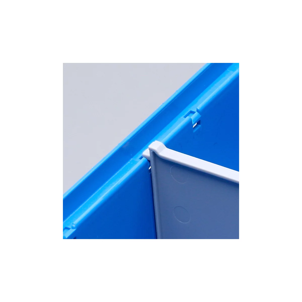Gros plan d'une boîte en plastique bleue avec un séparateur blanc inséré.