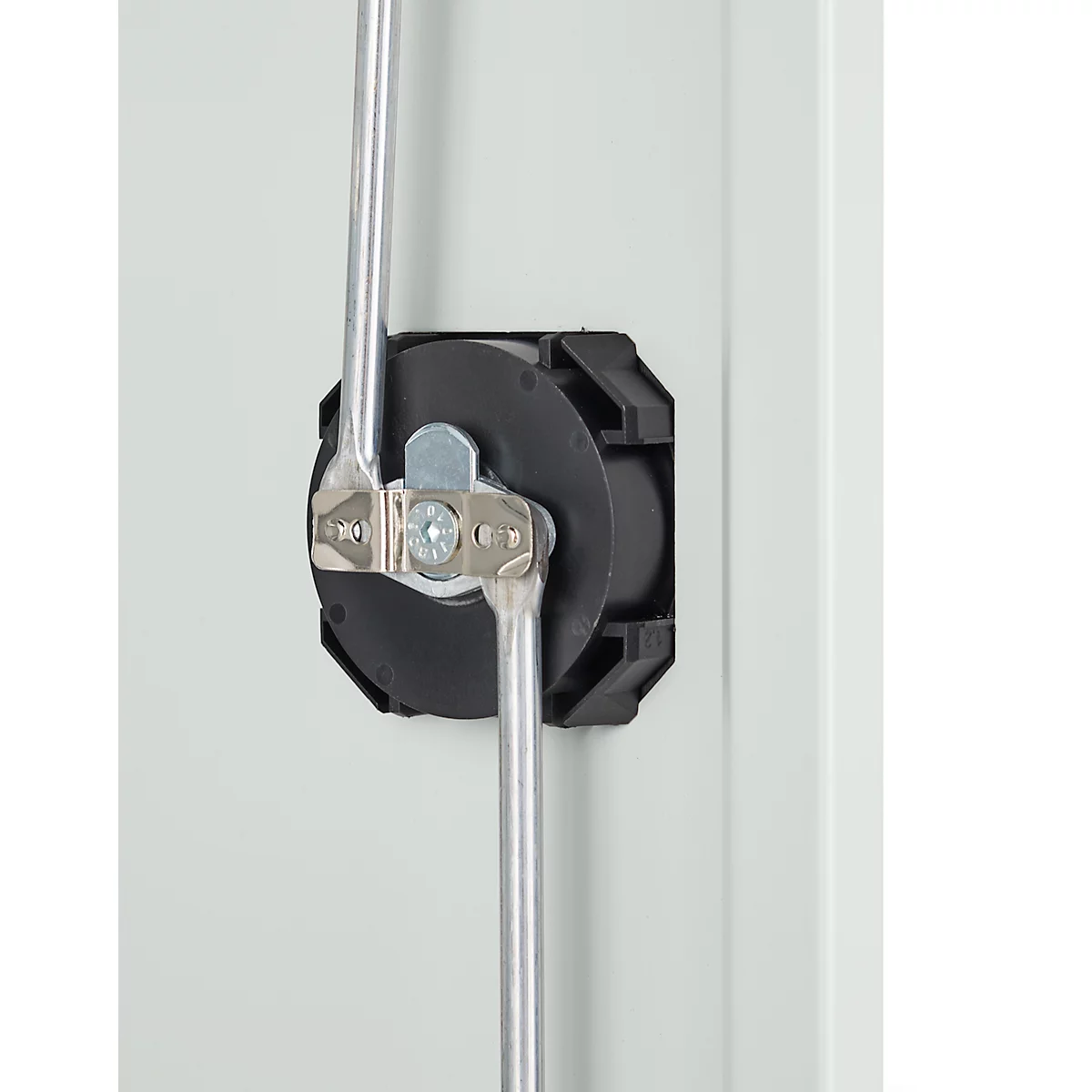 Close-up van een zwart kunststof apparaat met twee metalen staven en bevestigingsmiddelen tegen een lichtgrijze achtergrond.