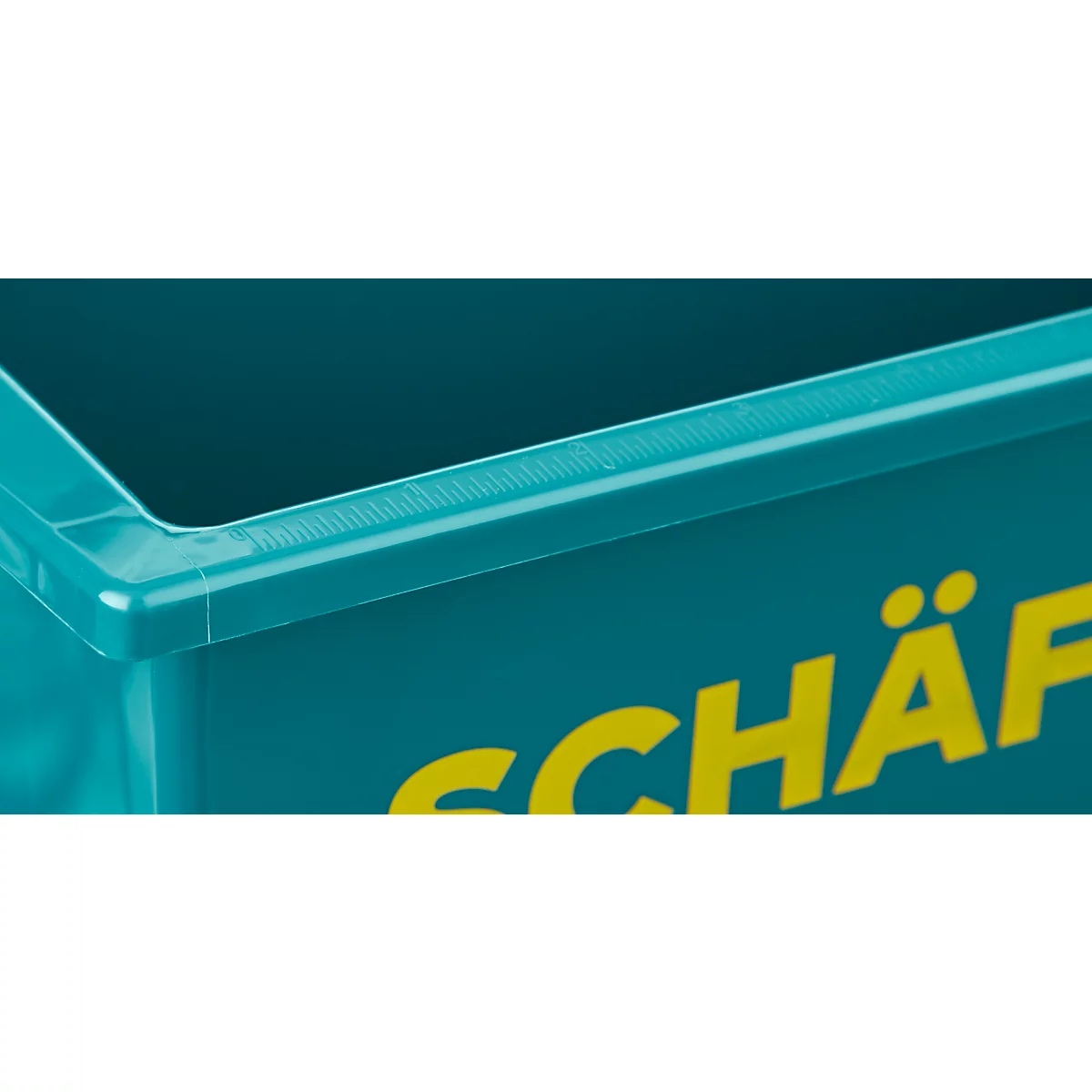 Detailansicht einer türkisfarbenen Kunststoffbox. Die obere Kante ist mit einem schwarzen Deckel versehen, darunter gelbe Schrift.