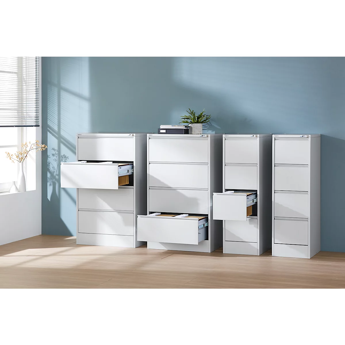 Armarios de archivos blancos con cajones abiertos sobre un fondo azul.
