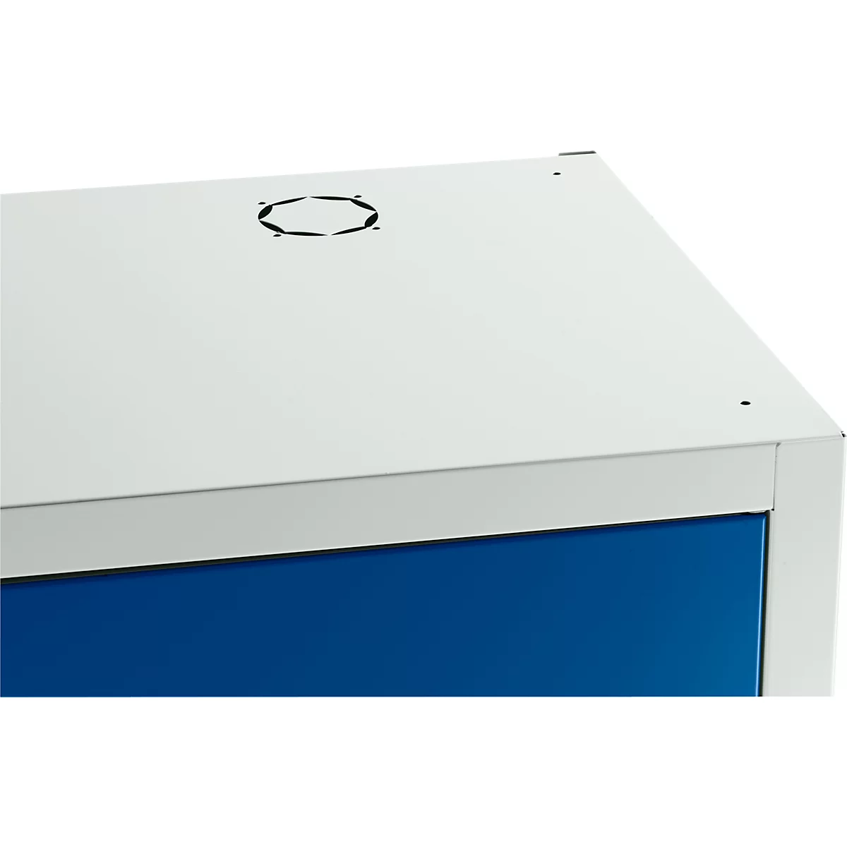 Armoire blanche avec porte bleue, fentes d'aération sur le dessus. Plan de détail du coin supérieur droit.