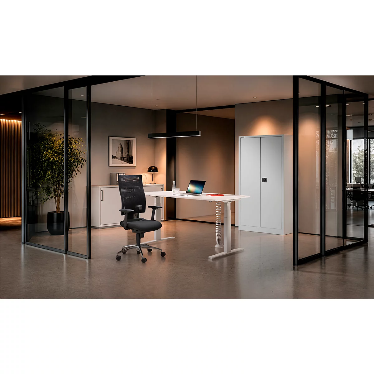Intérieur de bureau moderne avec bureau réglable en hauteur, chaise noire et armoire en métal blanc.