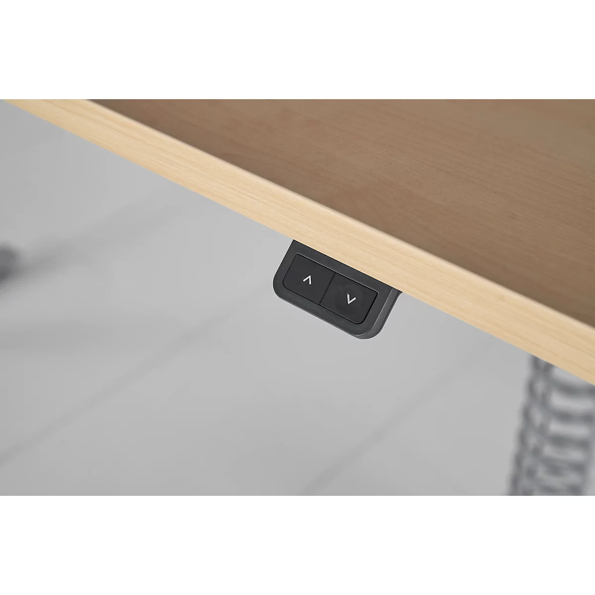 Gros plan des boutons de commande sous le plateau de la table. Touches fléchées pour le réglage de la hauteur.