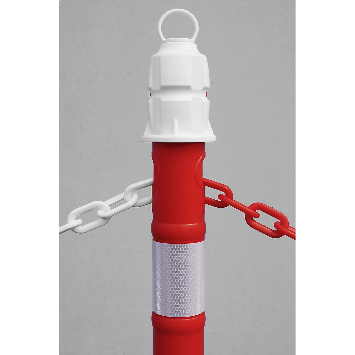 Red barrier post with white head, reflective tape and chains. The chains are white and red.