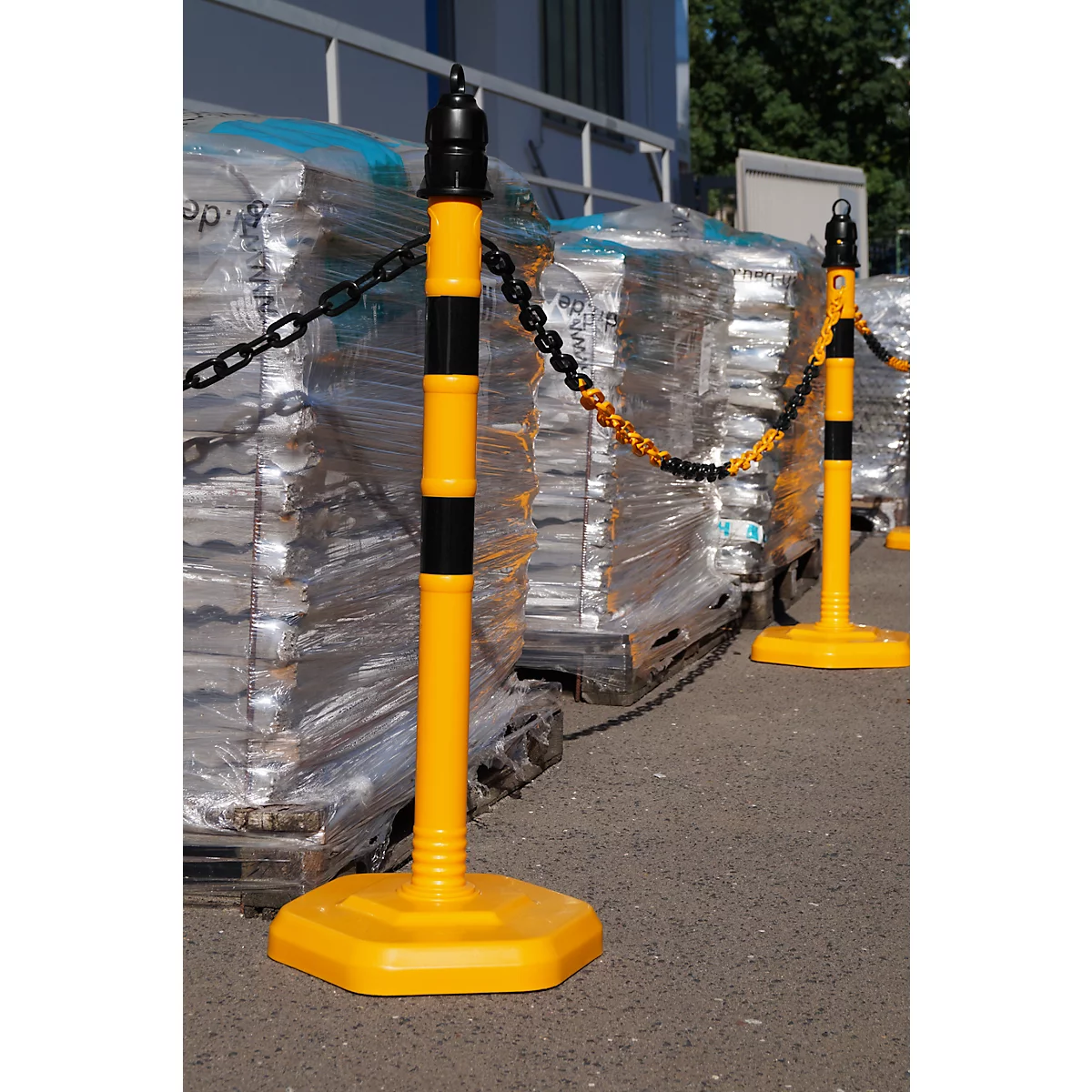 Yellow and black bollards with chain block access to packaged goods.