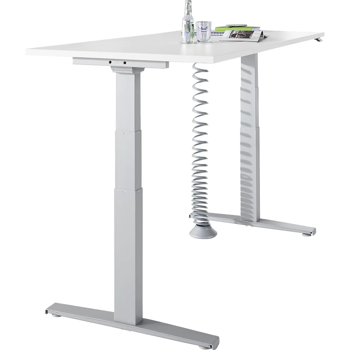 White, height-adjustable desk with gray legs, a water bottle and glass are on the table top.