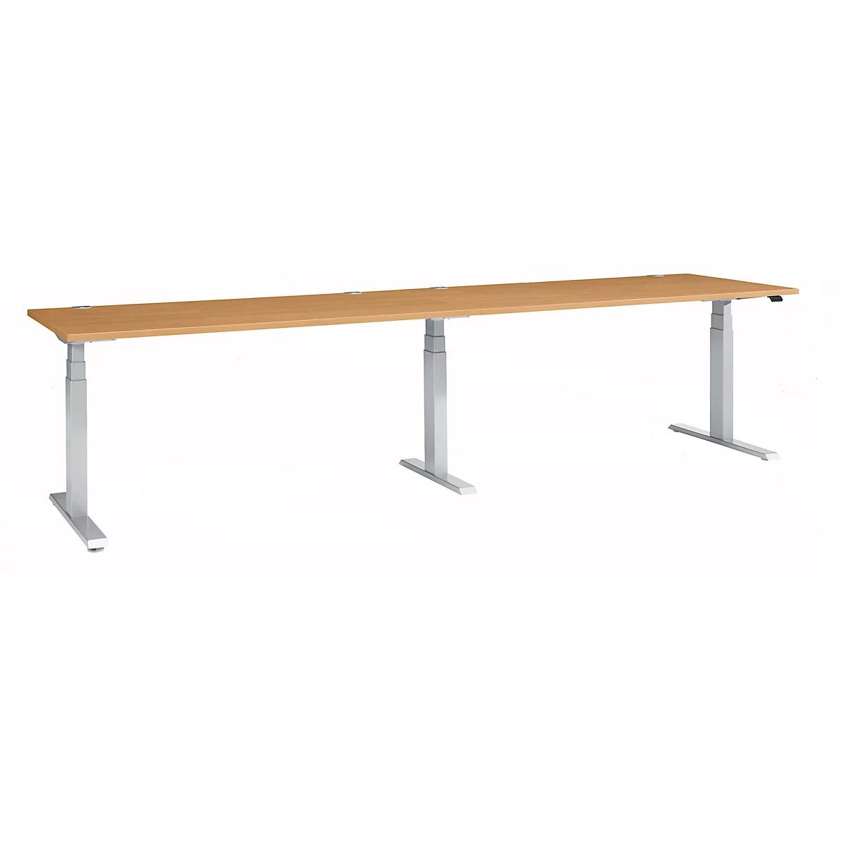 Long, height-adjustable desk with light brown tabletop and silver legs.