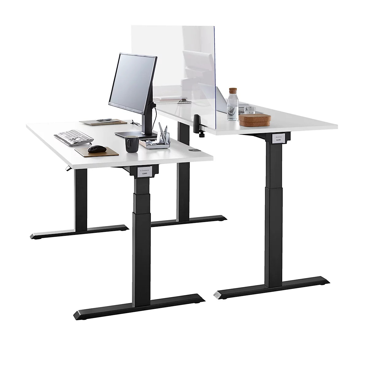 Two height-adjustable desks in L-shape, white with black frame. On one monitor, paper, mouse, pen holder, on it a partition.