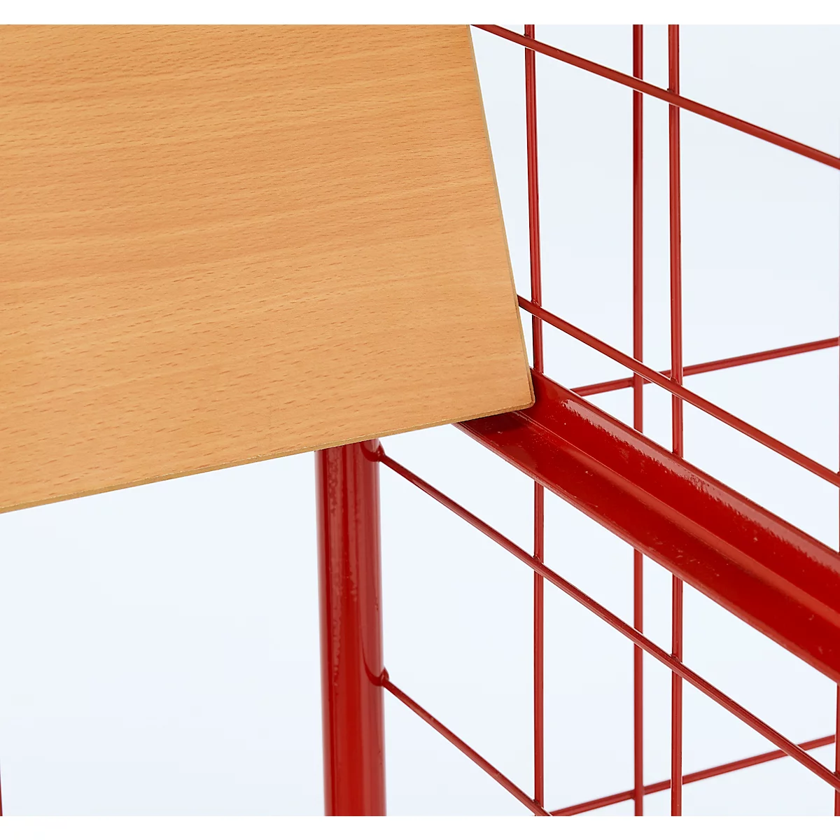 Detail van een stoel: houten rugleuning en rood geverfd metalen rooster.