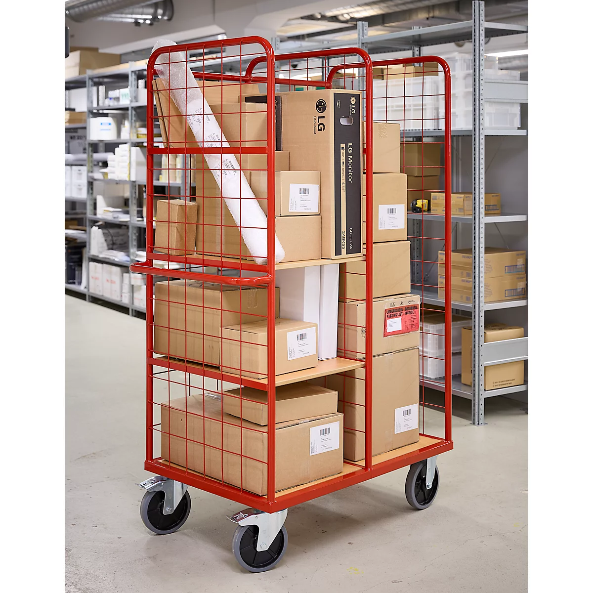 Rode transportkar vol dozen, waaronder een LG-verpakking. Op wielen, in een magazijn.