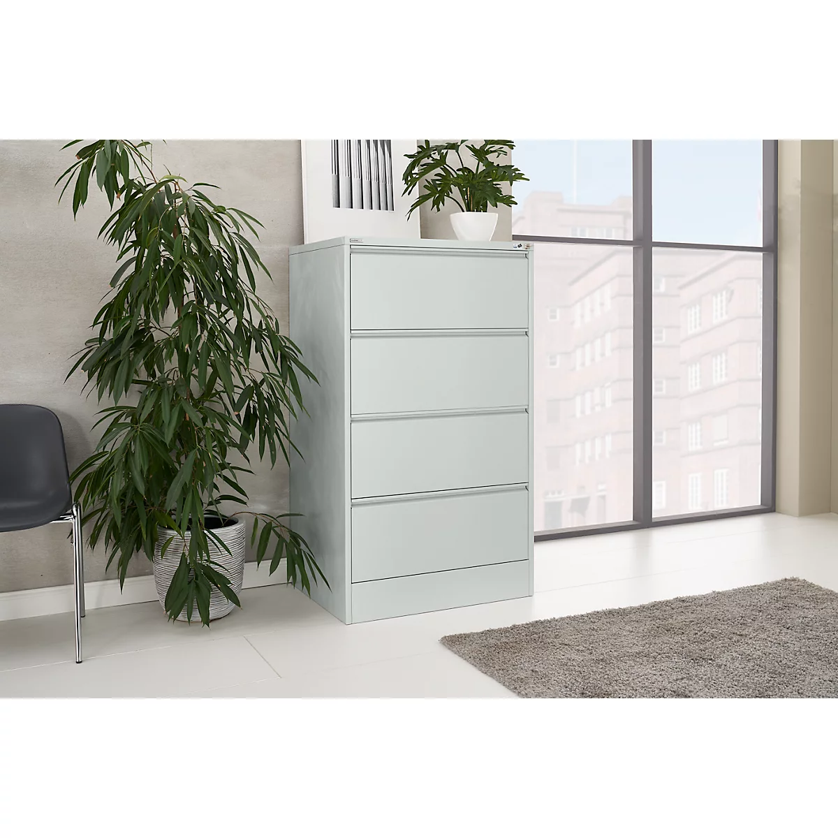 Light grey filing cabinet in an office with window and plant.