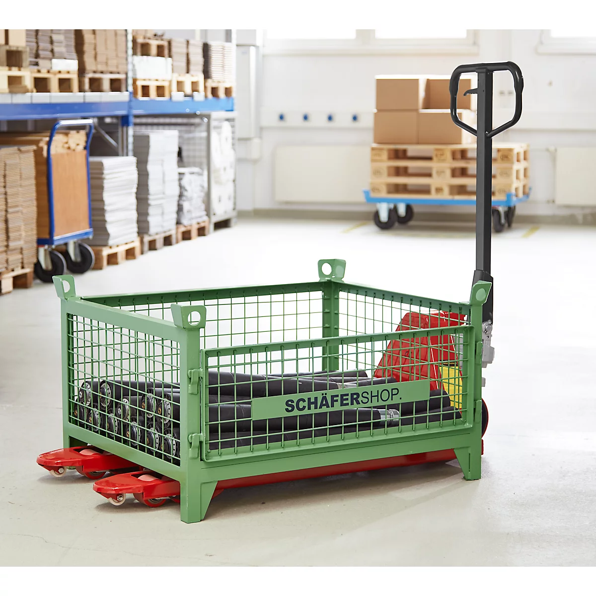 Groene rolkooi met banden en "SCHÄFERSHOP" logo in magazijn.