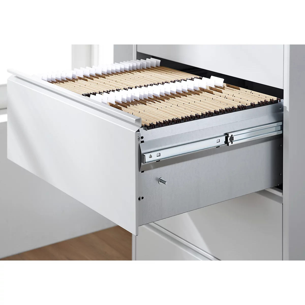 Geöffnete Schublade mit braunen Karteikarten. Schublade ist weiß, Metallführungsschiene.