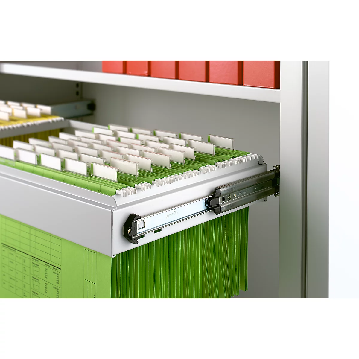 Pulled out drawer with hanging files; green files, white tabs.