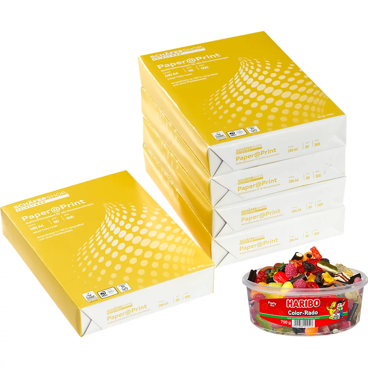 Mehrere Papierstapel mit gelber Verpackung und der Aufschrift Paper@Print. Dazu eine Schale Haribo Color-Rado.