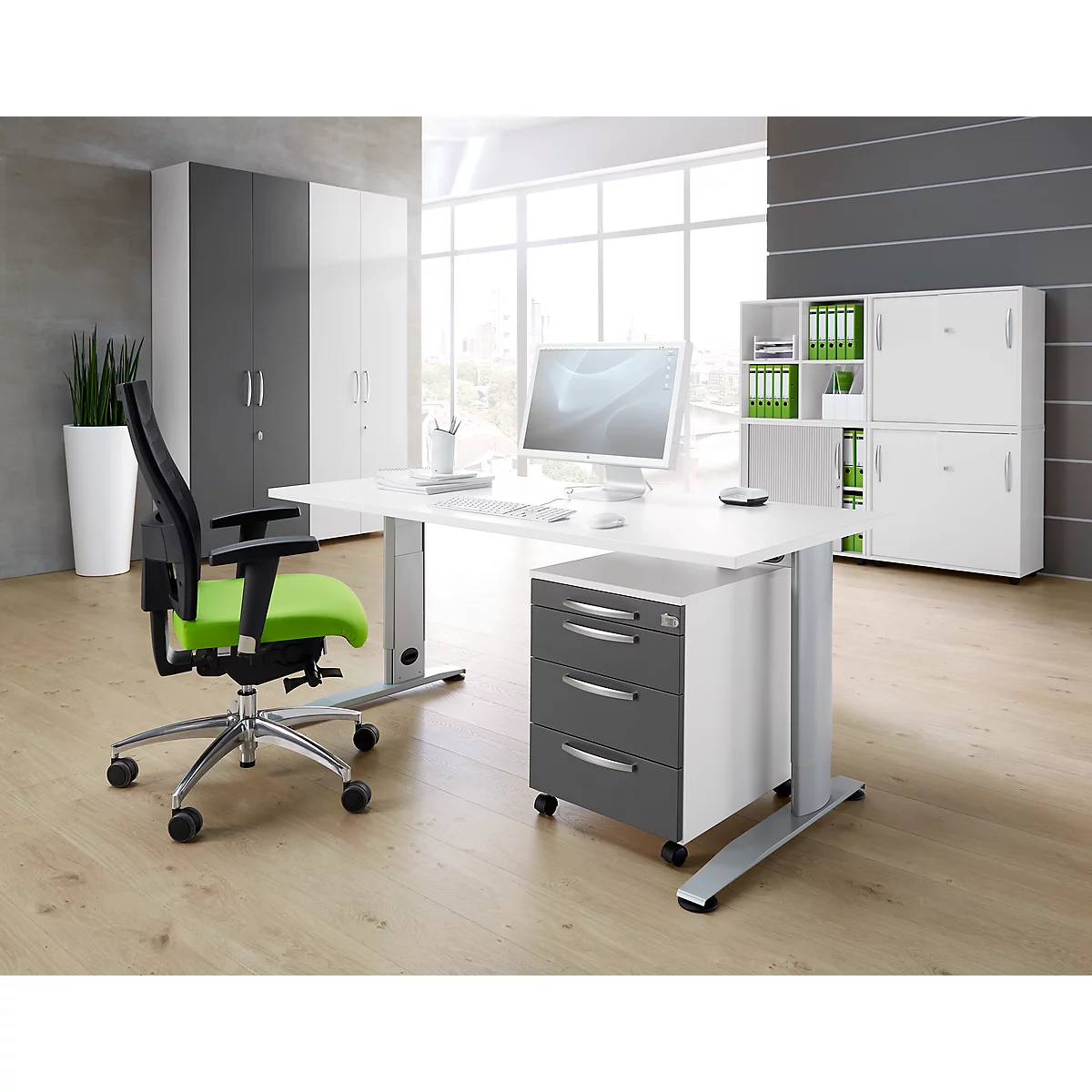 Office with modern desk, office chair with green seat, and white cabinets.