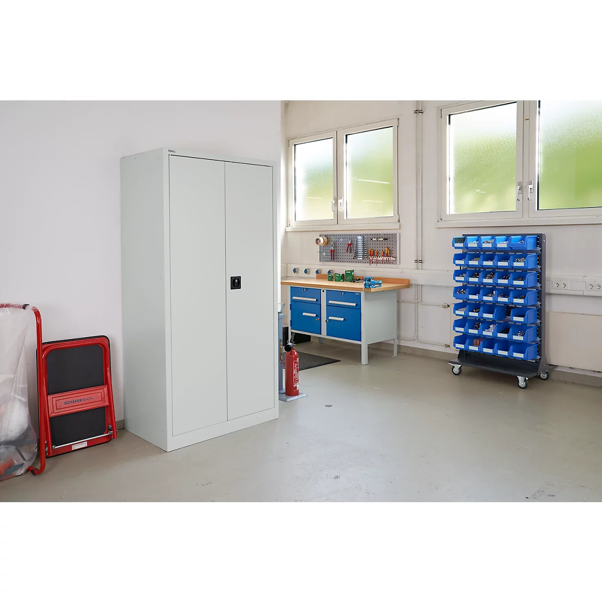 Workshop with workbench, cabinet, drawer system, and windows. Bright colors.