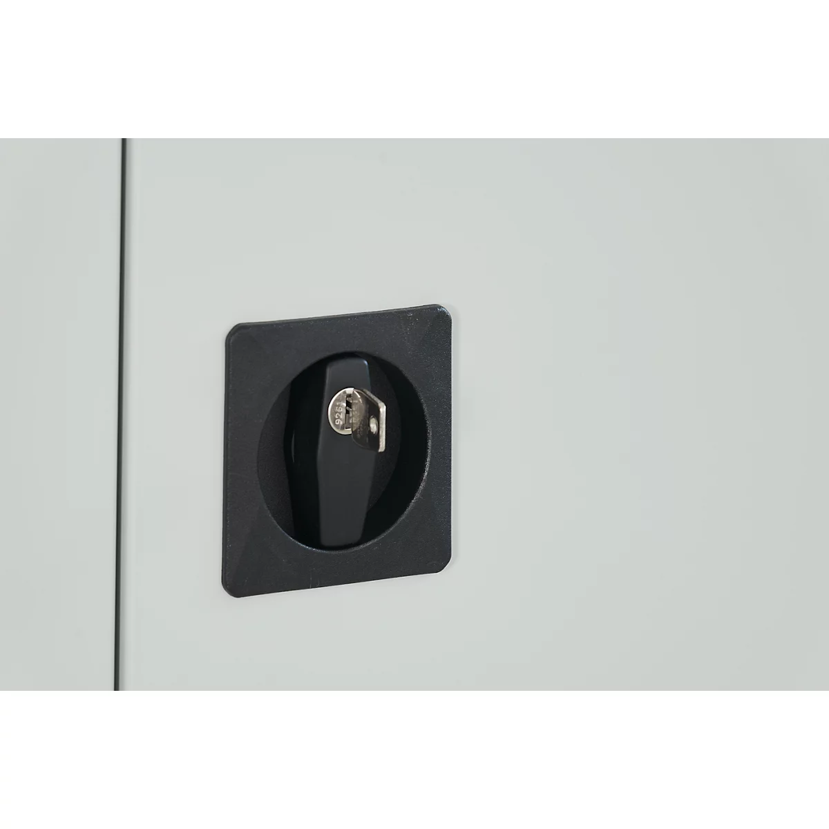 Black rotary latch with key in a square holder on a light grey surface.