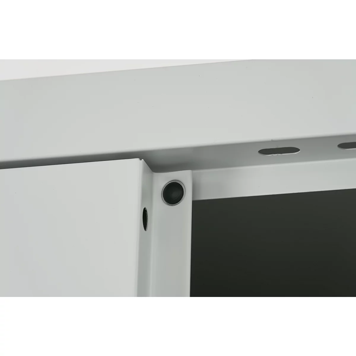 Close-up of a light gray metal structure. A metal part is held by a black button. Holes are set into the top metal part.